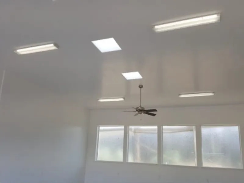 A garage lit by LED surface-mount lights with a ceiling fan