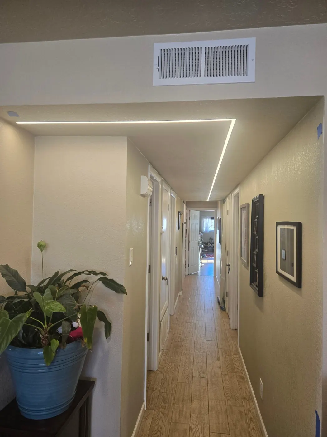 A long hallway with a continuous LED light line running along the ceiling edge