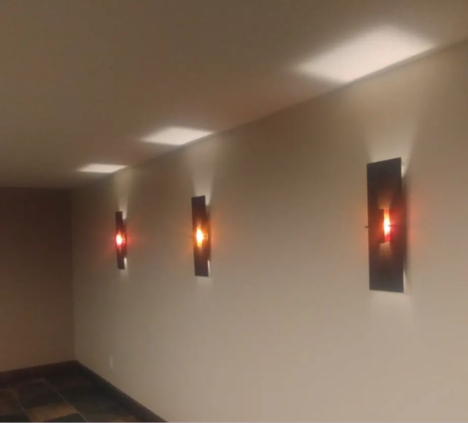 Warm wall sconces along a hallway